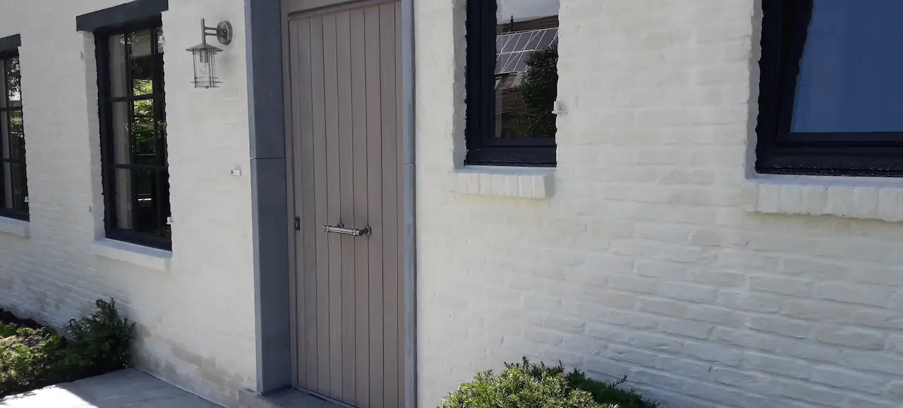 Zonnige crème gekaleide gevel met geschilderd buitenschrijnwerk