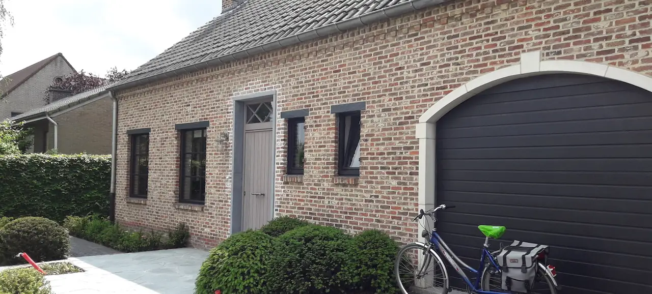 Baksteengevel met geschilderde ramen, deuren en garagepoort